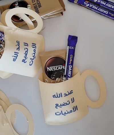 صورة توزيعات شكل كوب (بتصميمك الخاص) بداخله ظرف موكا من نسكافيه وشوكولاتة كادبوري اللذيذة