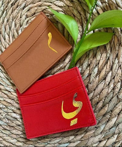 صورة محفظة (كارد هولدر)  باللون الأحمر بطباعة حرف عربي